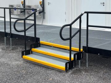 Modular Step Units with optional Handrails fitted on both sides, providing additional support and stability for safer access to the raised platform.