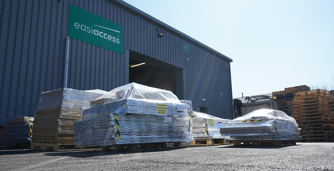 Wrapped pallets of modular ramp components outside an Easiaccess warehouse, ready for dispatch.